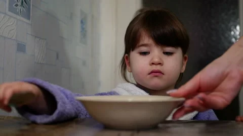  Mom puts a plate of breakfast on the table for the child. Stock Footage 168148024