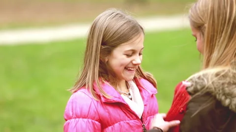 Mom putting cap on daughter's head and kissing her in forehead Stock Footage 59554623
