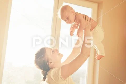 Mom raised the baby in her arms above her head Stock Photos