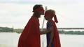 Mom in superhero costume kisses son forehead, embracing, support in beginnings 4k or 4k+ Resolution