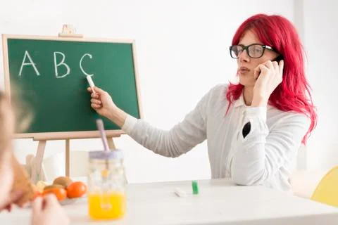Mom Talking on Phone While Teaching Kid ABC's with a Chalkboard Stock Photos