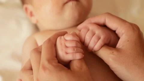 Mom tenderly embraced the baby's small hands Stock Footage