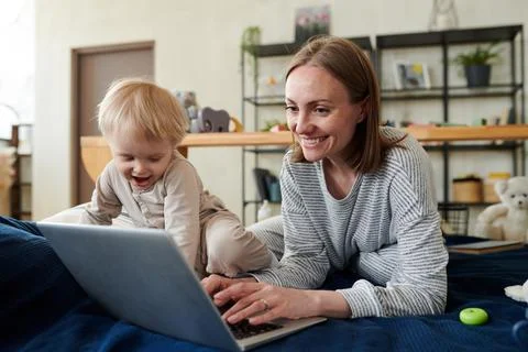 Mom working on laptop online Stock Photos