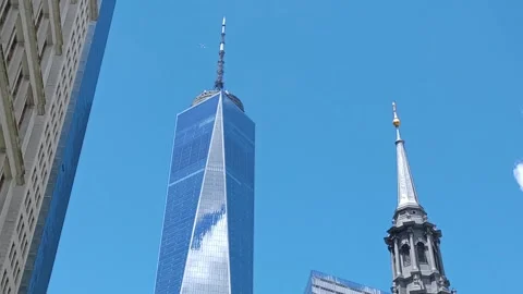 A Moment in Motion: Plane Passing Between One World Center and Trinity Church Stock Footage 277122086