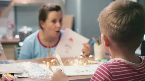 Moms and son are preparing for the new year and Christmas learn to draw Santa Stock Footage 157178439