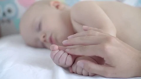 Mom's handles gently stroking the sleeping baby on the handles. Slow motion Stock Footage 80325433