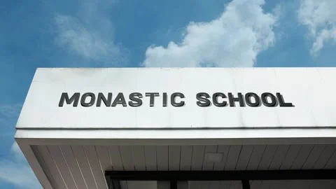 Monastic school word sign displayed on building with blue sky background Stock Footage 318763228