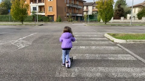 Monastier di Treviso, Italy, October 24, 2020: a kid girl riding a kick scooter. Stock Footage