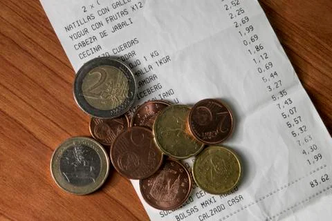 Monedas con ticket de compra y productos y precios Stock Photos