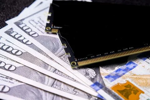 Money and computer memory module arranged on a dark surface showing a mix of Stock Photos
