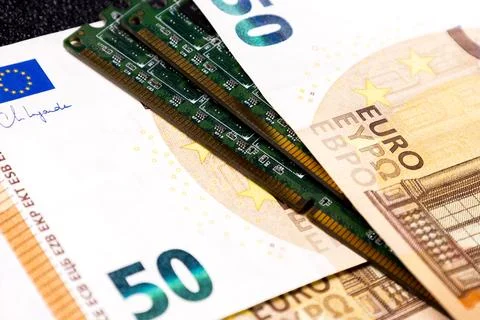 Money and computer memory modules are placed together on a flat surface with a Stock Photos