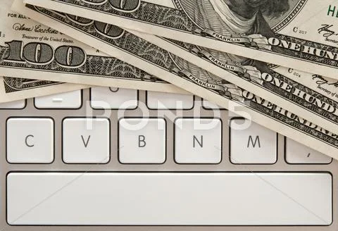 Money bills on computer keyboard with spacebar Stock Photos
