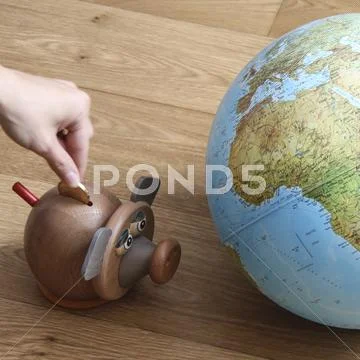 Money box and globe Stock Photos