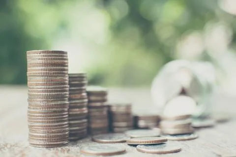 Money coin stack step growth with blurred background jar and green leaf, Sa.. Stock Photos