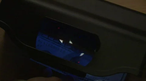 Money into conterfeit detector Stock Footage 479749