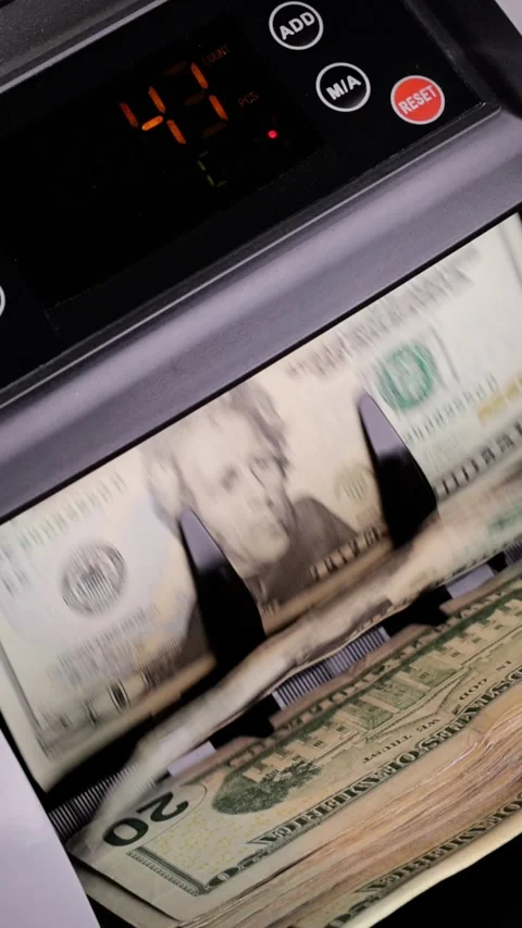 Money counting machine counting US bills. Vertical Video. Stockbeeldmateriaal 337435645