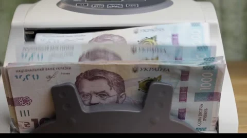 Money counting machine processing stack of 1000 Ukrainian hryvnia banknotes Stock Footage 336205878