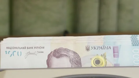 Money counting machine processing stack of 1000 Ukrainian hryvnia banknotes Stock Footage 336206187