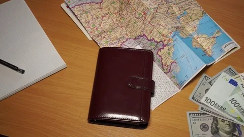 Money, dollars, euro, notepad, paper, pencil, geographic atlas are on the tab Stock Footage 99794548