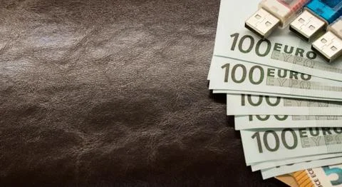 Money in an envelope on a brown leather notepad background Stock Photos