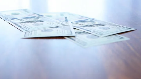 Money falling gently on the table in daylight Stock Footage 85979521