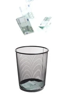 Money flying into the trash Stock Photos