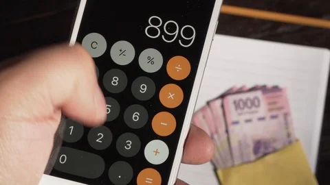 Money -  Hand holding a calculator in the background  bills Vídeo Stock 123732592