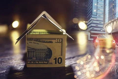 Money house on stack of dollar bills on wooden table, close up. Double expo.. Stockfoto's
