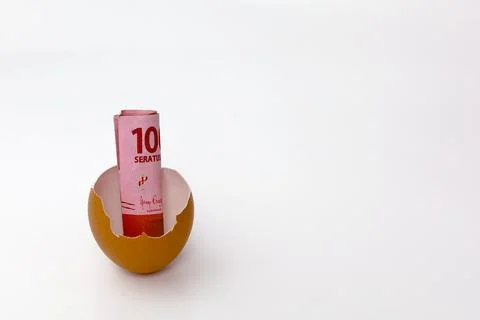 Money inside cracked eggshell. Indonesian currency in cracked eggshell Foto stock