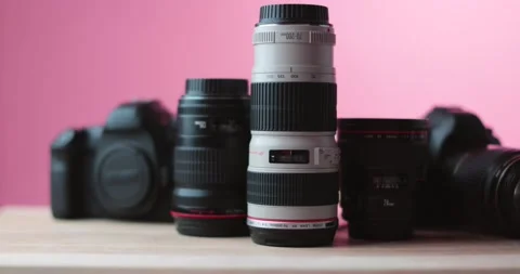 Money raining down on expensive camera lenses red studio light white background. Stock Footage 237546917