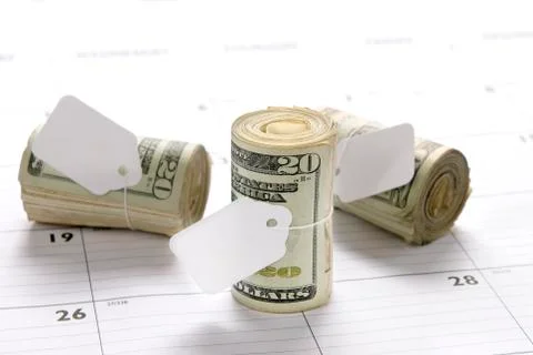 Money rolls on calendar Stock Photos