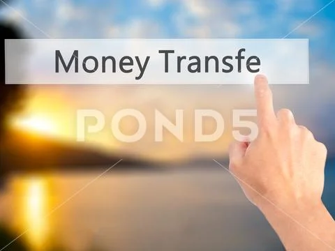 Money Transfer - Hand pressing a button on blurred background co Stock Photos