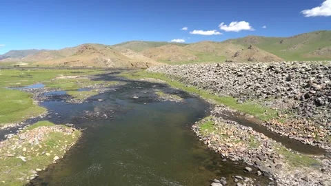 Mongolia arid river landscape cuts through rocky plains - Travel Destination Stock Footage 339703933