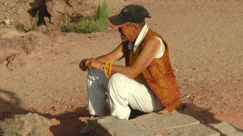 Mongolia. An old lama rests sitting on a stone block in the Gobi Desert. Stock Footage 110798317