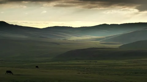 Mongolia sunset glows above grassland hills - Rolling Plains and Distant Ridges Stock Footage 339706765