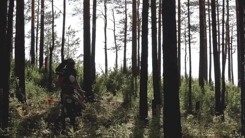 Mongolian archer makes way through dense forest with weapons. Video stock 82371077