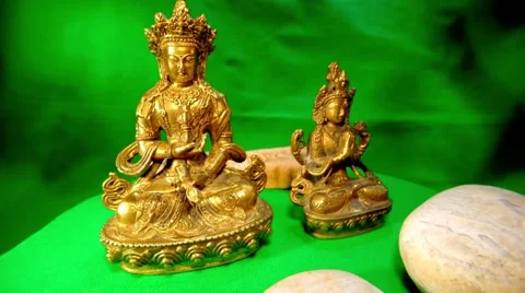 Mongolian Iron Pair of Figures and Few White Stones Spinning on Green Stock Footage 62635806