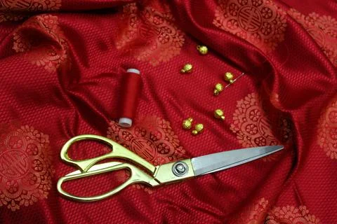 Mongolian silk fabric with buttons, thread, needle and scissors Stock Photos