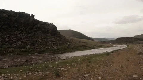 Mongolian small river close to the rocks and mountains under cloudy sky Stock Footage 57402725