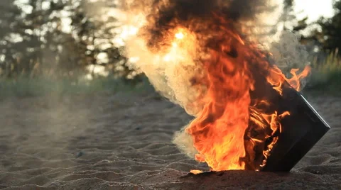 Monitor burning in the sand at sunset Stock Footage 6523390