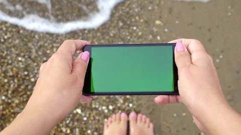 Monitor of device with empty blank green screen. Woman at sandy beach Stock Footage 97227168