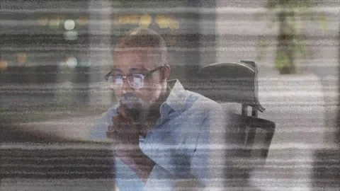 Monitor glow drawing man closer, he reaching keys, reviewing tech data while Stock Footage 332937054