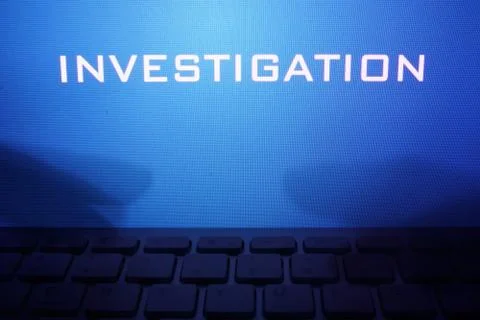 Monitor with message investigation and hands on a keyboard. Stock Photos