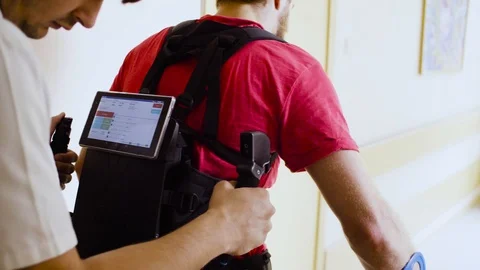 Monitor of the robotic exoskeleton on the back of the walking man Stock Footage 94080869