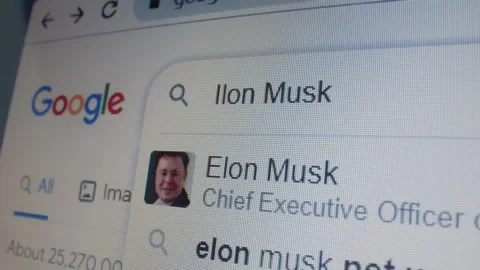 Monitor screen with a google page and typing the search term Elon Musk Stock Footage 235158812