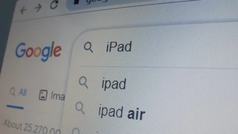 Monitor screen with a google page and typing the search term iPad. Stock Footage 235161059
