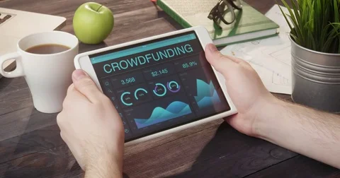 Monitoring crowdfunding data using tablet computer at desk Video stock 80699817