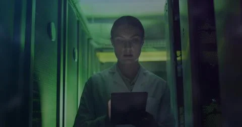 Monitoring data on tablet, technician in lab coat navigating server aisle, Stock Photos