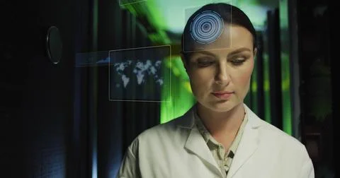 Monitoring female IT engineer using holographic displays on server racks in Stock Photos