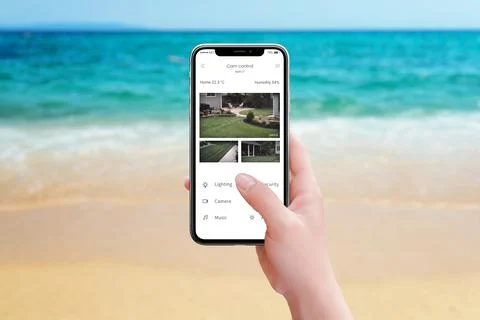 Monitoring home security cameras from the beach using a smartphone app Foto stock